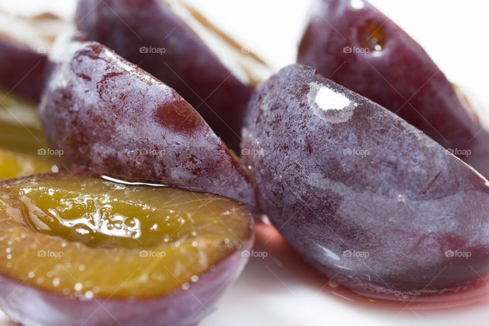 macro closeup of slice of juicy delicious ripe plum. fresh and frozen berries concept