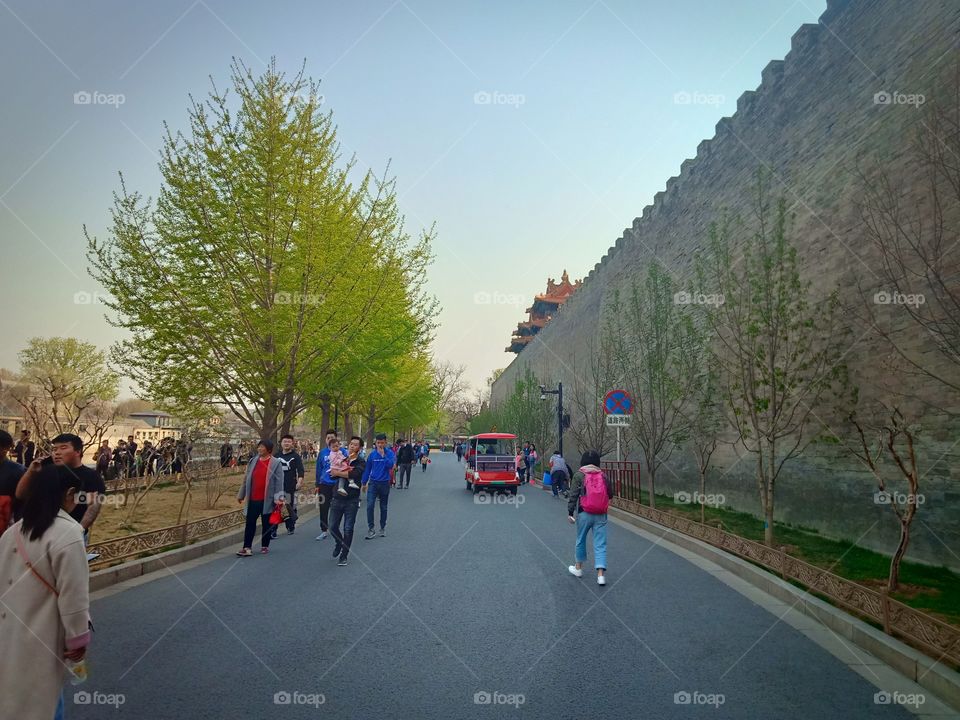 People walking on the road beside walls of forbidden city palace