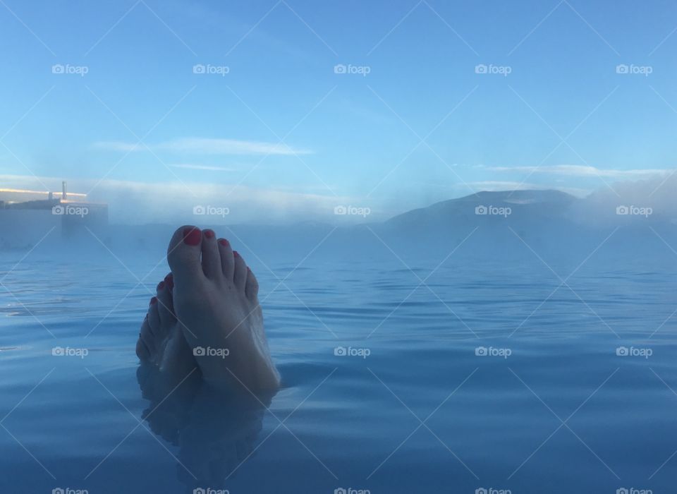Women's feet in thermal water