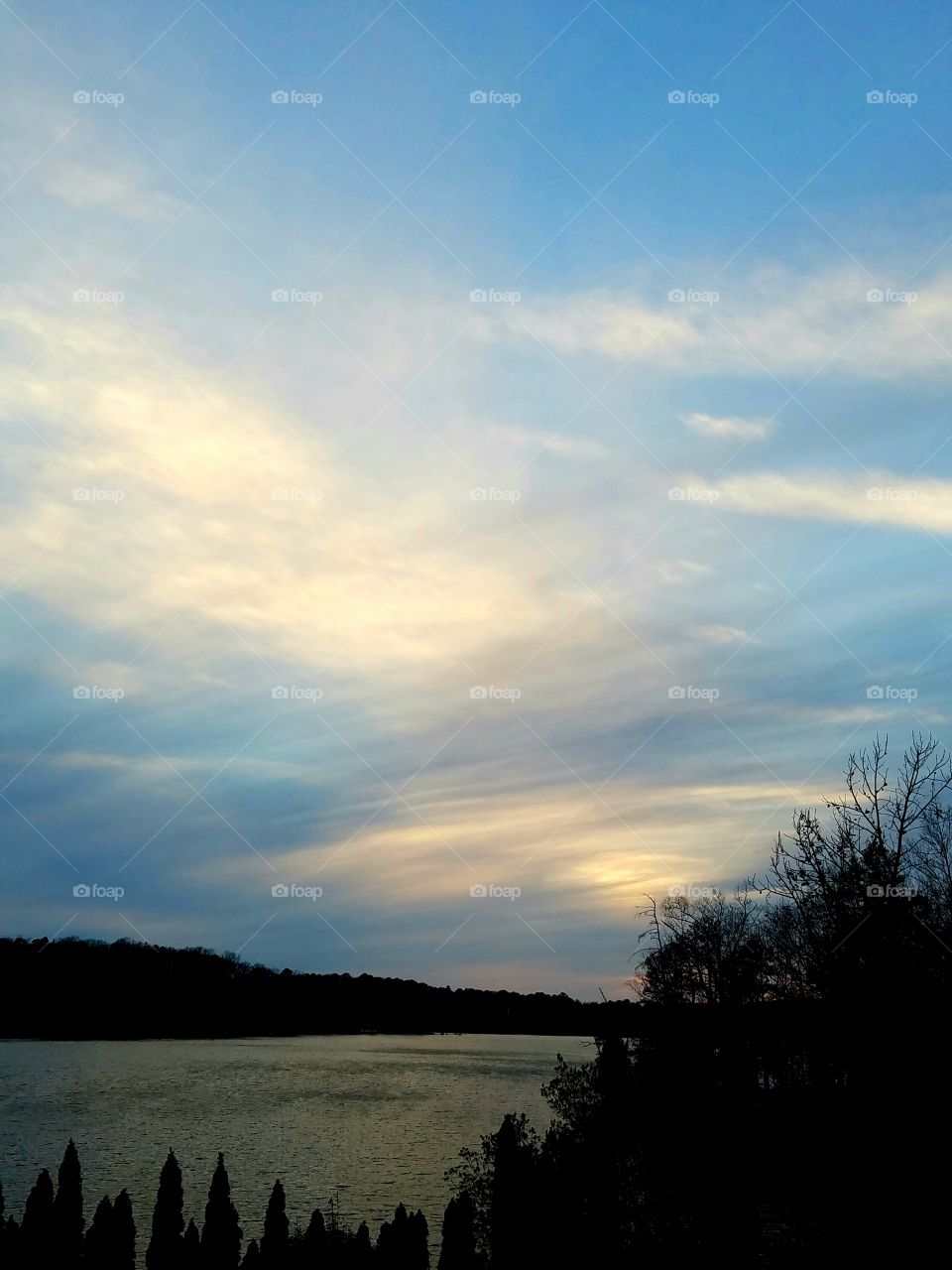 sunset over the lake on cloudy winter day.