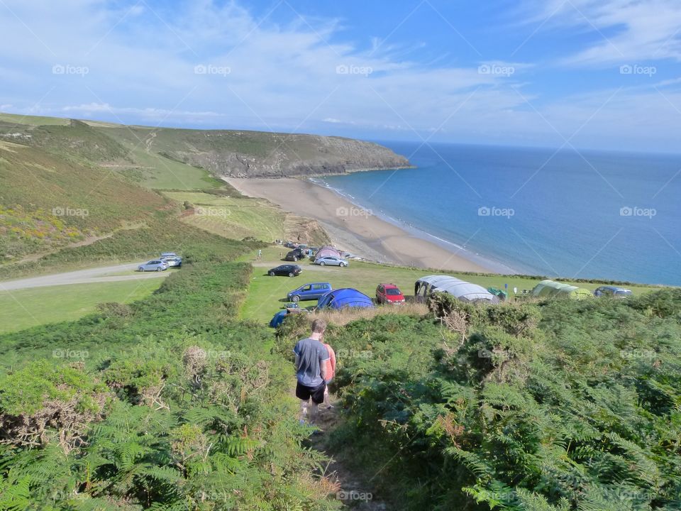 A lovely sunny day walking from the campsite to a long golden beach surrounded by green field
