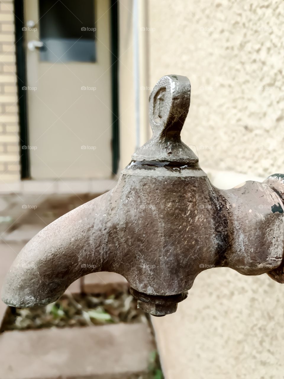 Antique old retro vintage iron outdoor water tap faucet spigot pipe, water flowing turned on