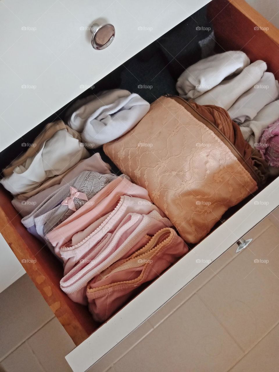 A white drawer of pink underwear