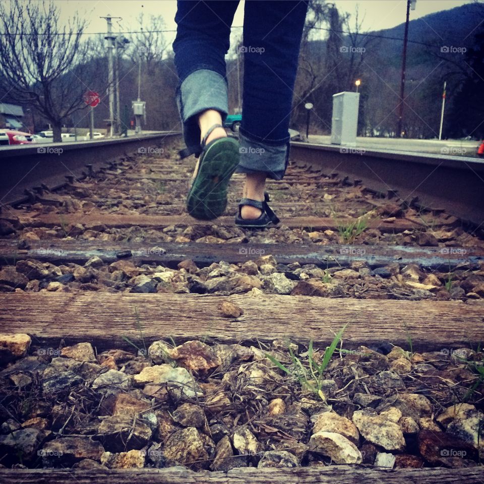 On tracks. Girl walking on tn railroad 