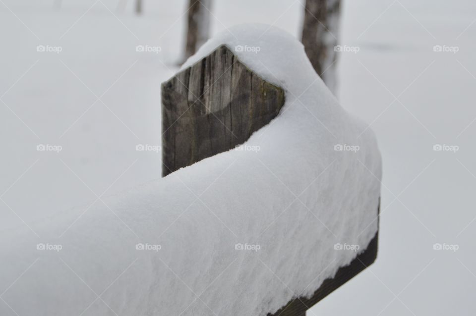 Fresh snow on wooden fence