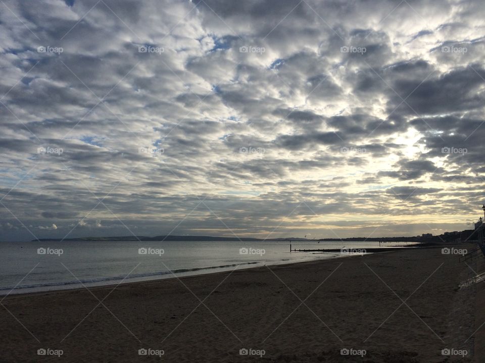 Stratocumulus cloud formation over Bournemouth beach in Dorset at sunset. Beside the sea. Seaside cloud formation. Seaside at sunset. Sunset by the sea. Sunset on the beach. UK beach in summer. 