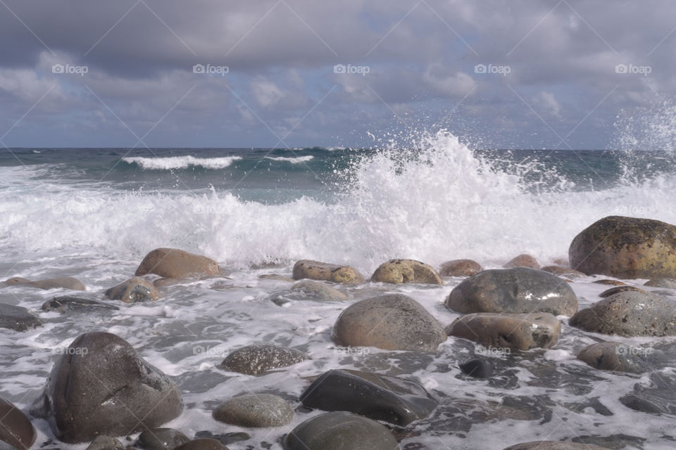Waves crashing against boulders that now look like rocks