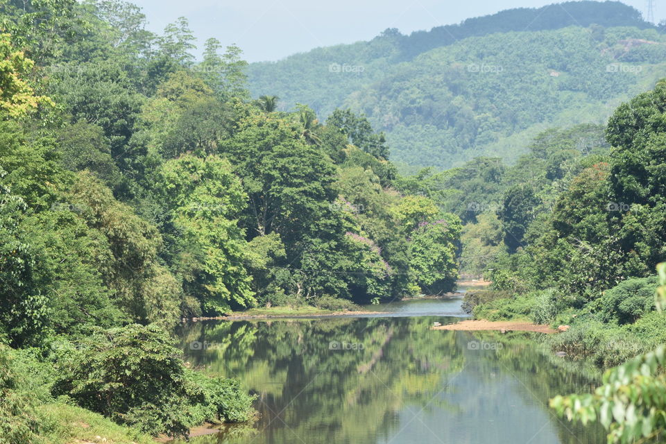 It is a beautiful river calmly flowing through forest and beautiful mountains