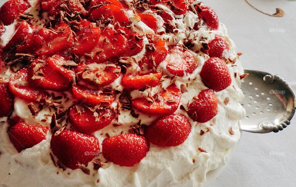 Fresh strawberries and chocolate on a creamy cake 