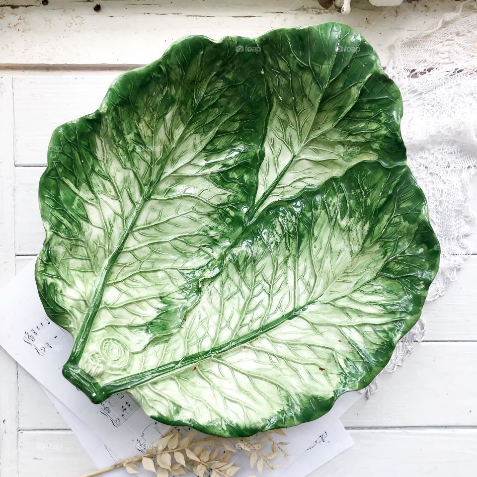 Old big dish in cabbage leaves form