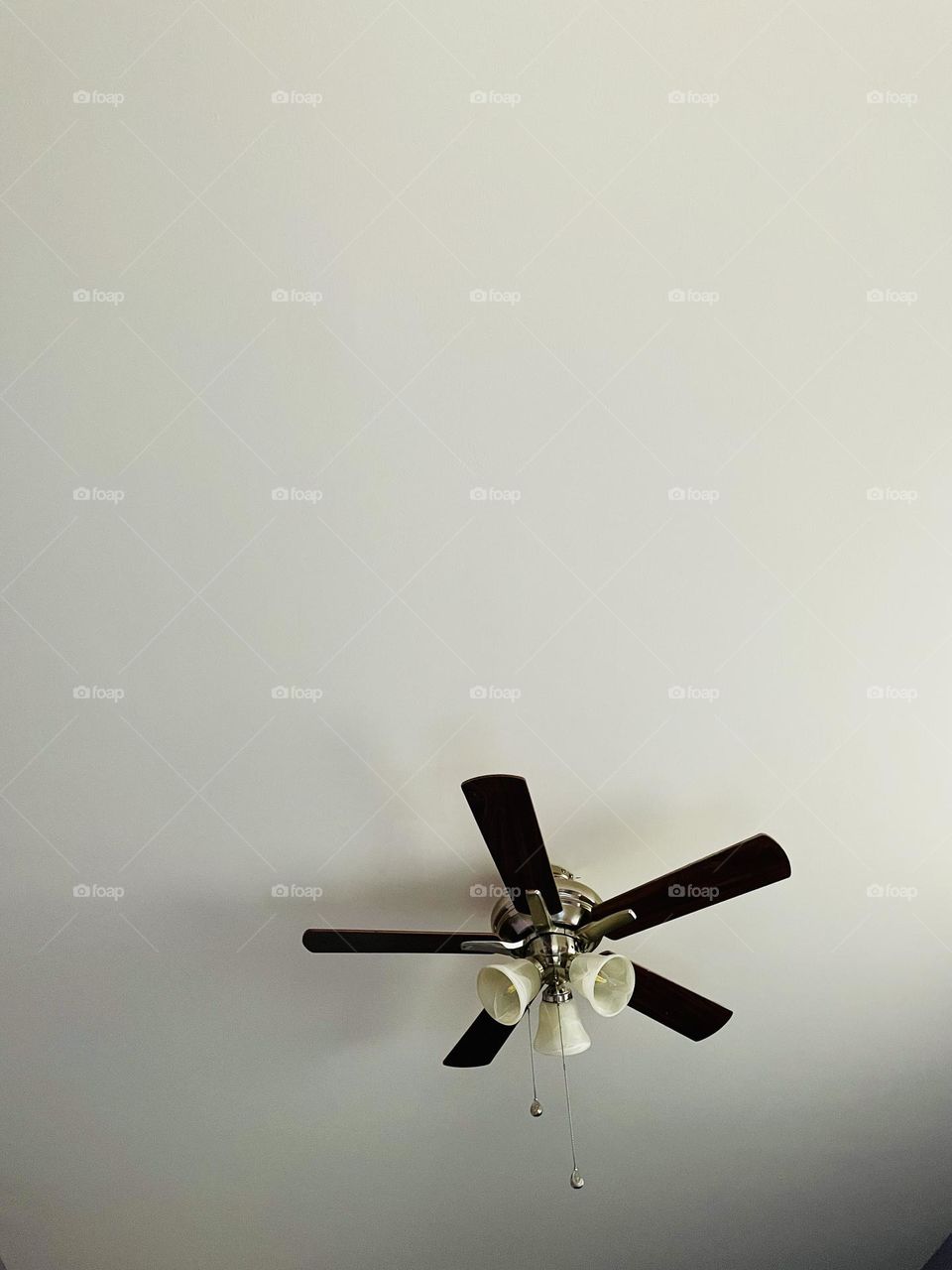 Ceiling fan in a bedroom, looking up, view from the bed, lying in bed looking up 