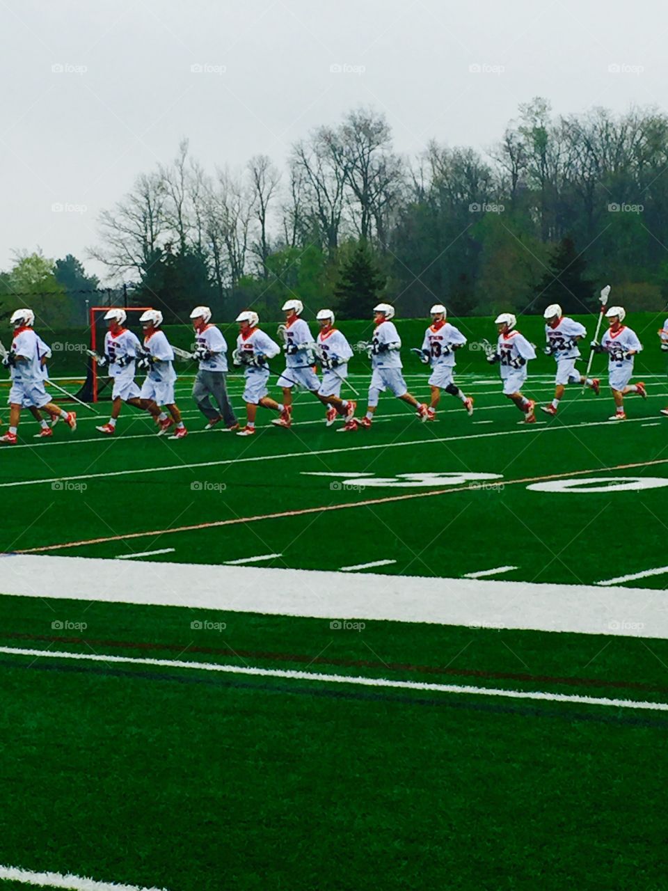 Men's Varsity Lacrosse team team line running on field