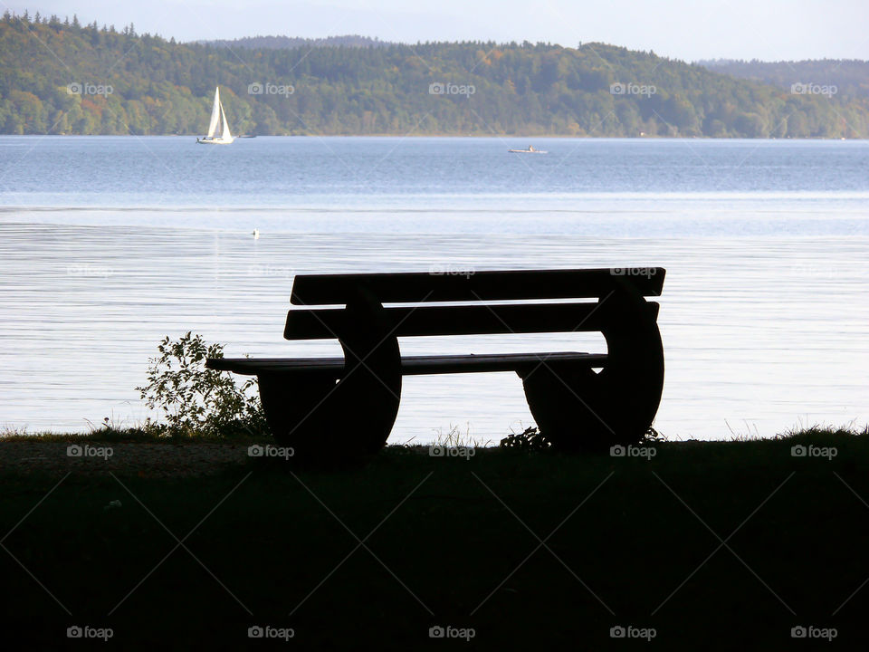 Silhouette of bench at lake Starnberg in Starnberg, Germany.