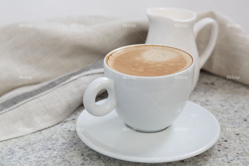 Coffee cup with milk on granite table