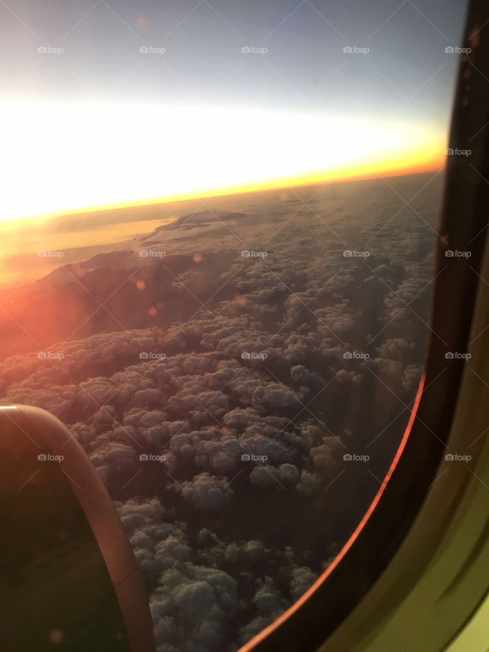 Unlimited freedom above the clouds. View  from the airplane on clouds at sunset time. 