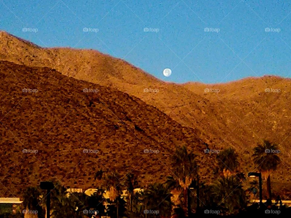 Morning Moon going down by mountain.