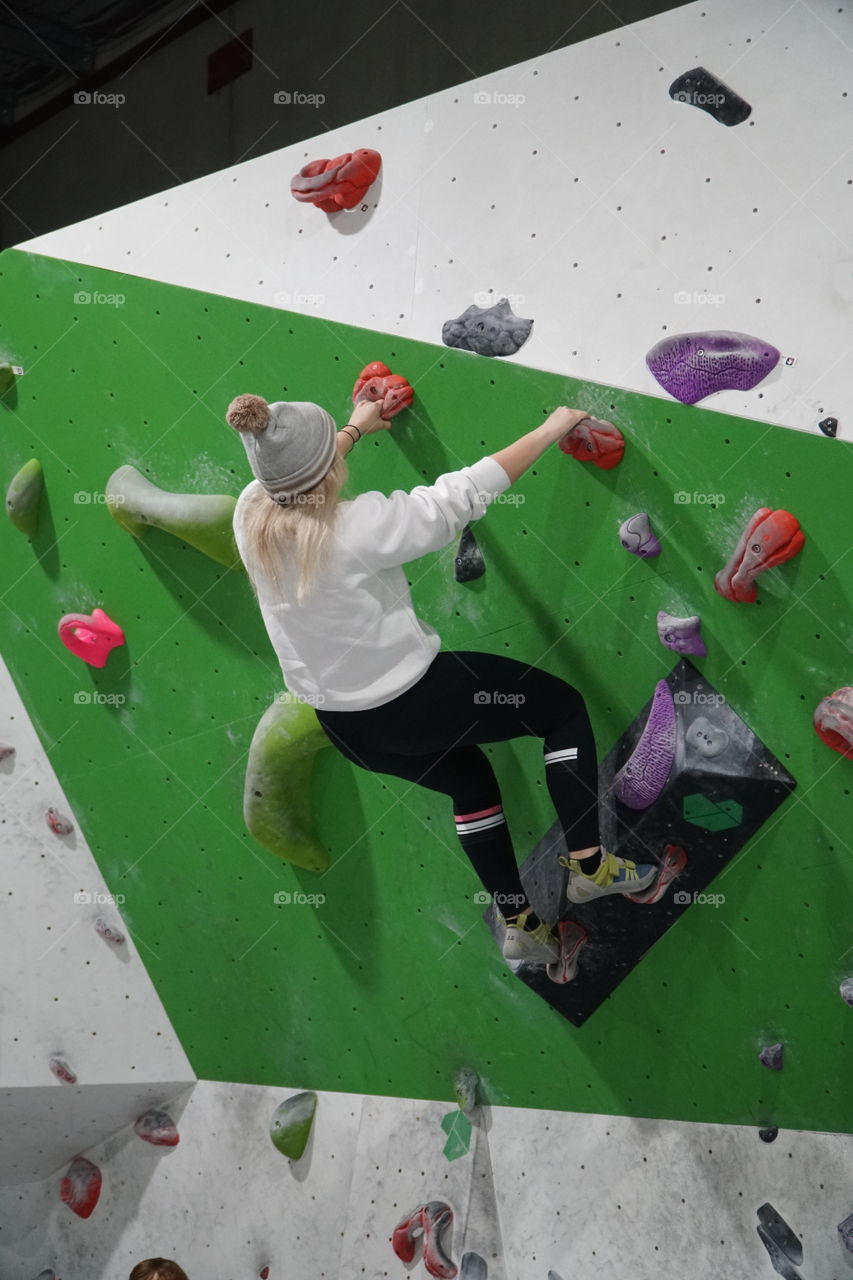 Girl climbing a rock wall
