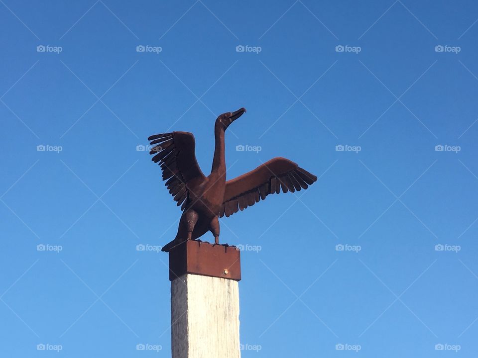 Rusted Metal sculpture atop tower Cormorant 