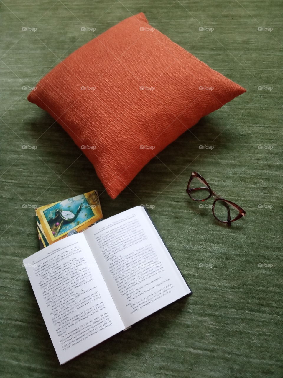 Combinations of colours and textures, shown with orange pillow, books and glasses.