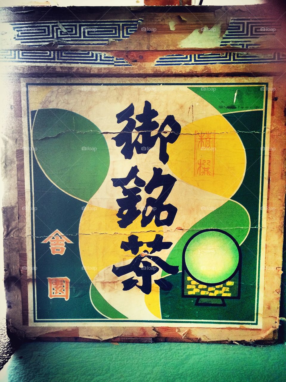 Japanese letters on a green paper on the wooden box. 