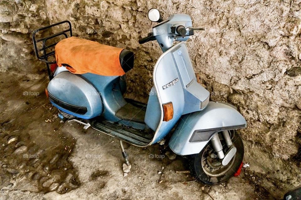 Classic Italian scooter parked in the shade.