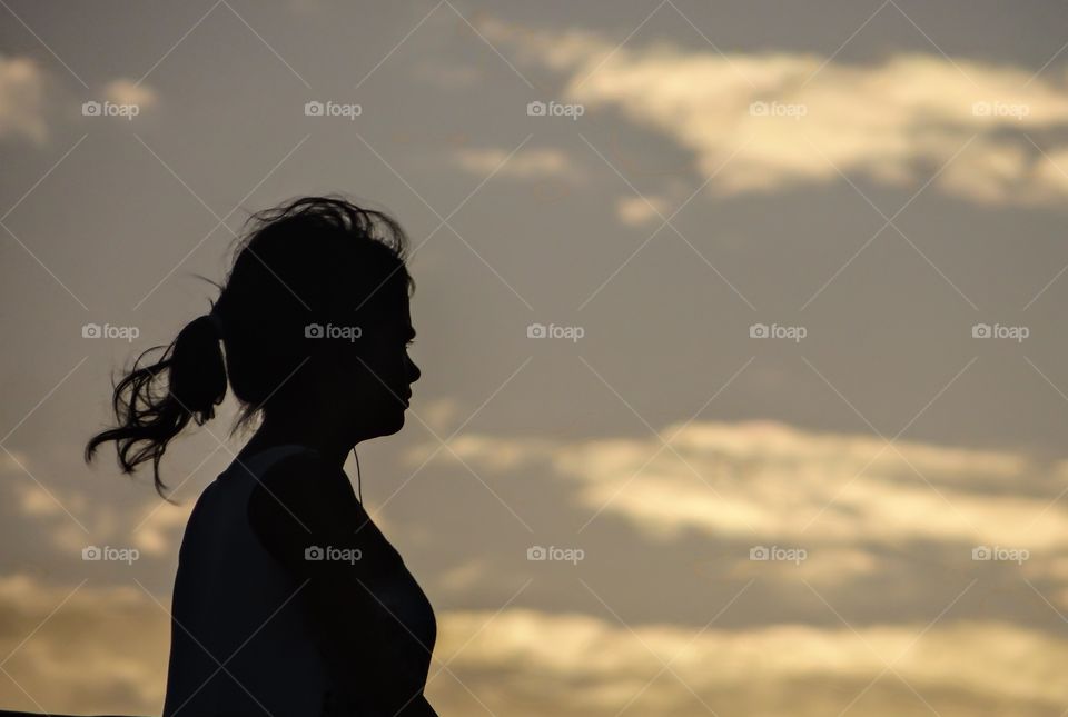 Silhouette of woman against sky at sunset