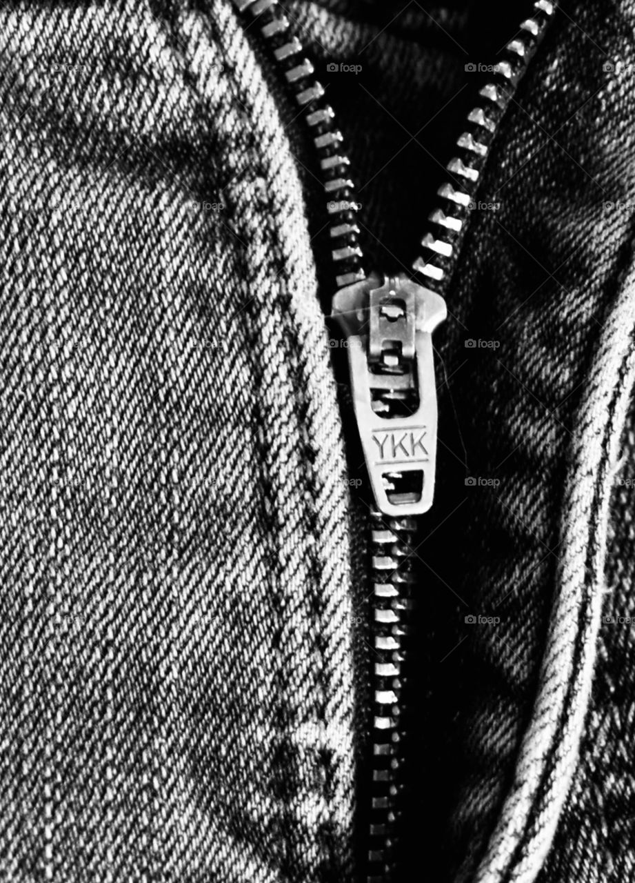 Black and white metal zipper on blue jeans