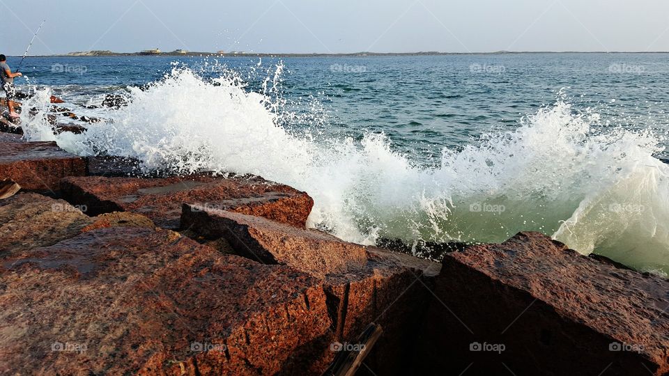 Waves crashing toward rock