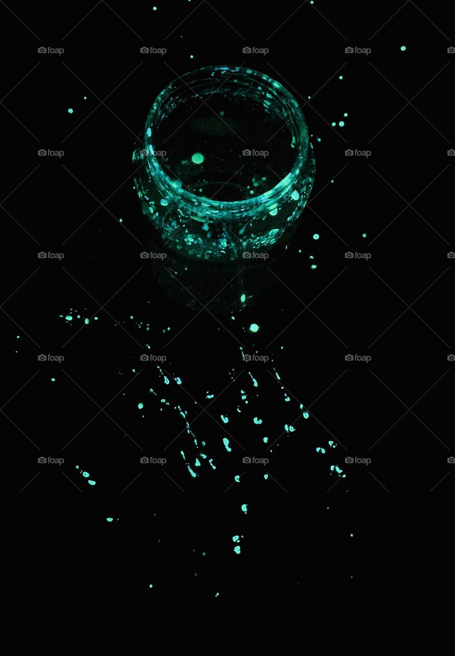 Artificial Light; Green Glow Stick fun. Jar with water and green  dibutyl phthalate splatter