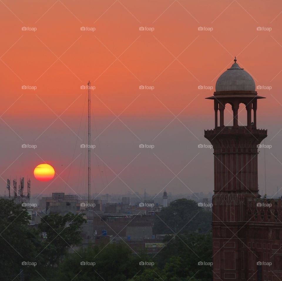 Minaret with sun set in the background 
