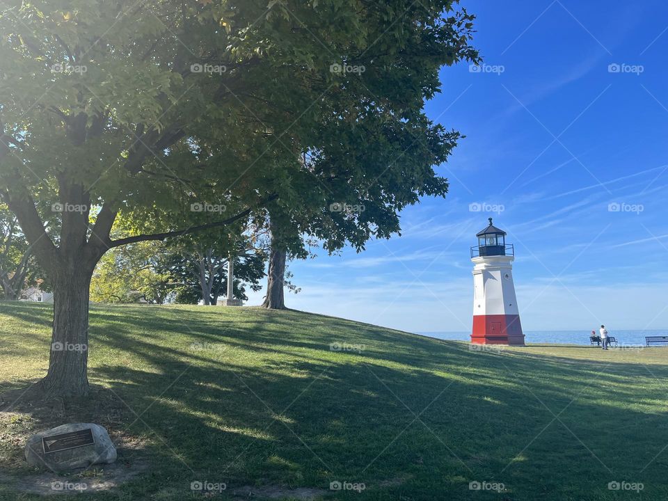 Lighthouse in Vermillion Ohio with bright blue skies and white lined clouds