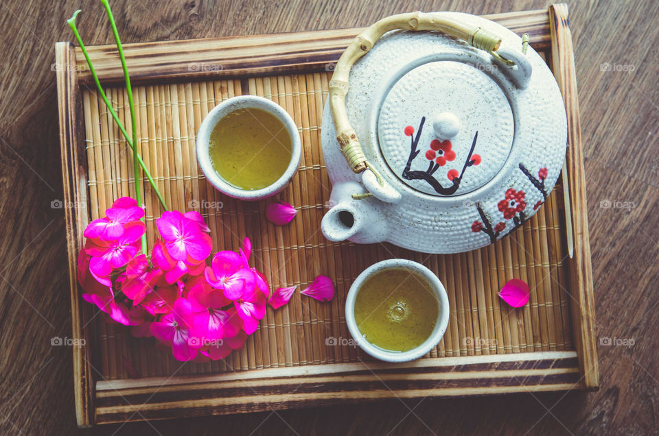 Cup of green tea with teapot