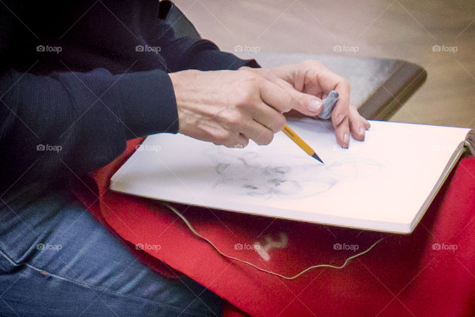 Close up of hands of female artist working with pencil sketch