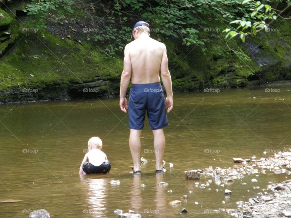 father and son moment near stream
