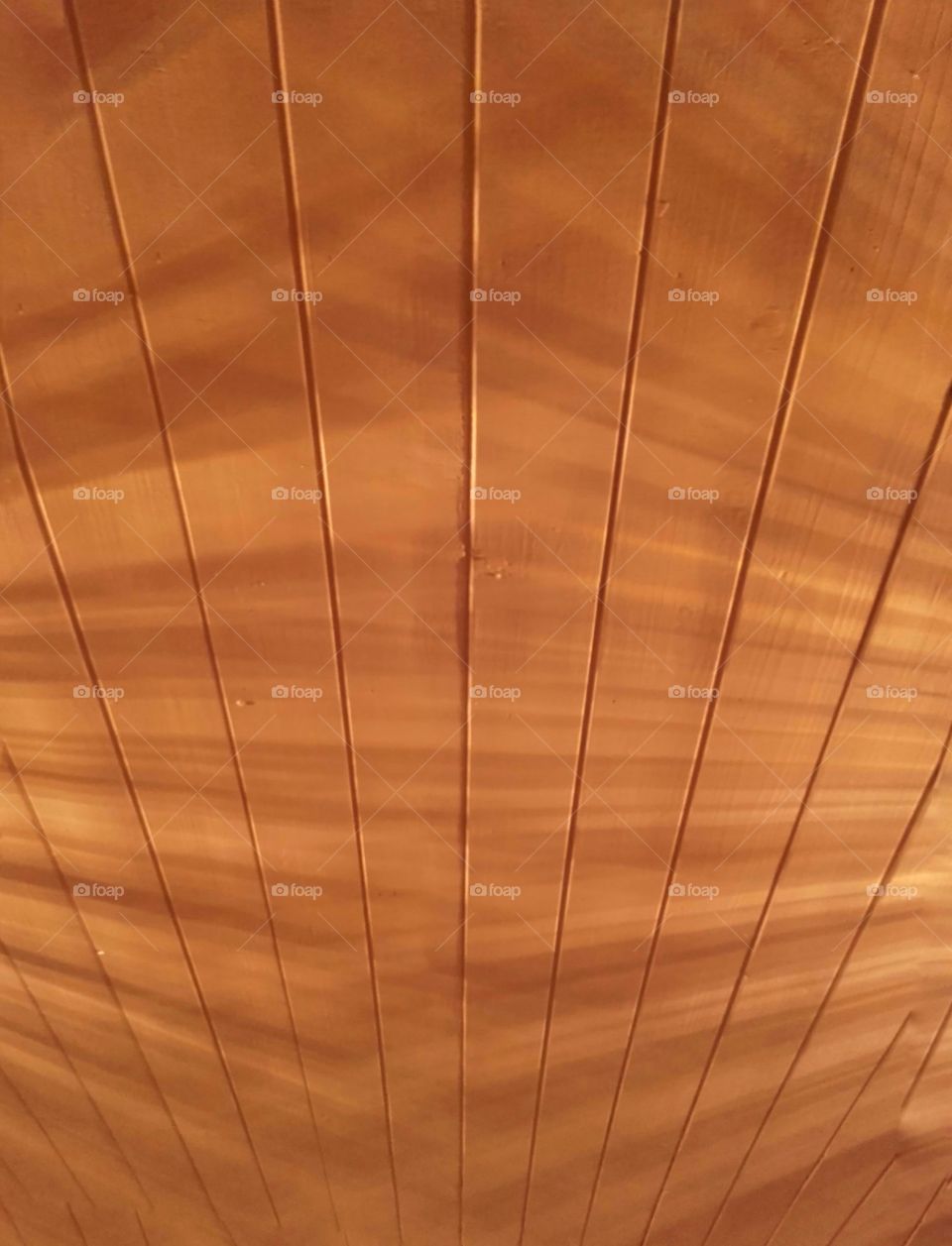 Timber ceiling coloured a light yellow colour from ambient lighting