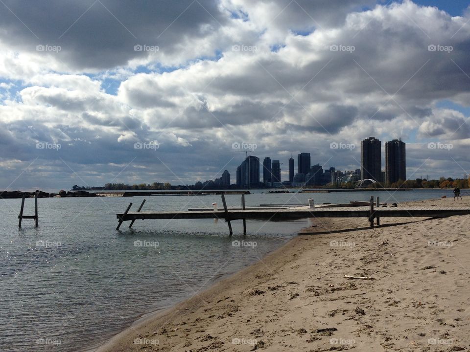 A broken dock with a cityscape in background. 