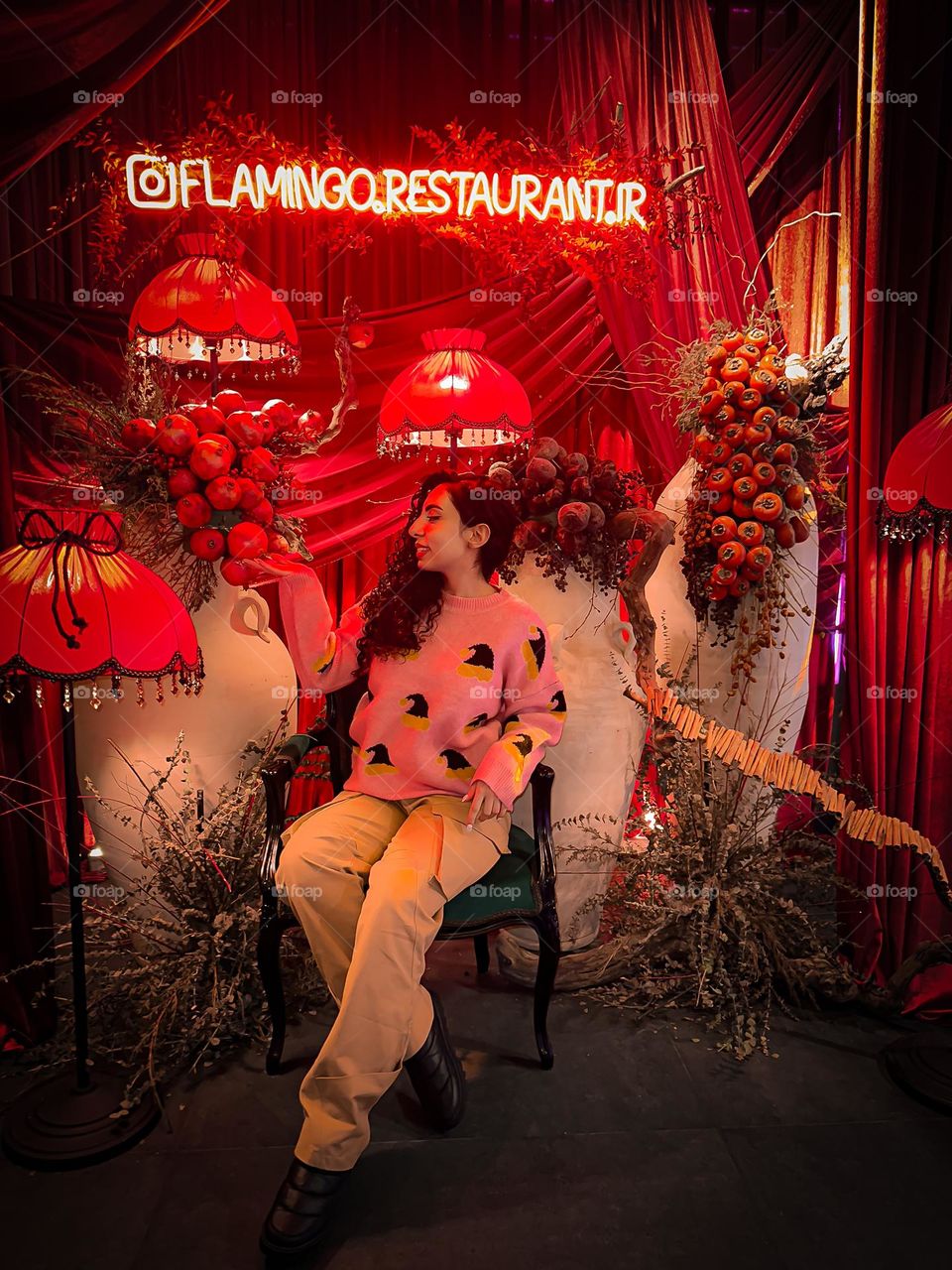 A girl with curly hair and clusters of pomegranates and persimmons