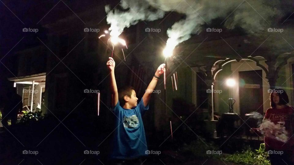 Boy holding sparklers at night