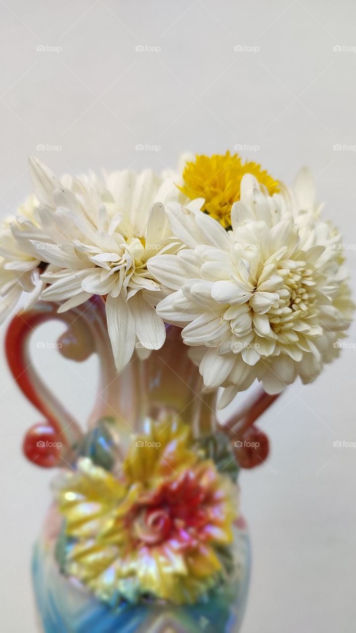 Beautiful white flowers in a colourful flowerpot with a flower sculpture, Flowers in a vase, colourful vase, white flowers in a vase