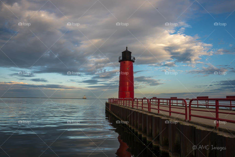 Red lighthouse at sunset on Lake Michigan