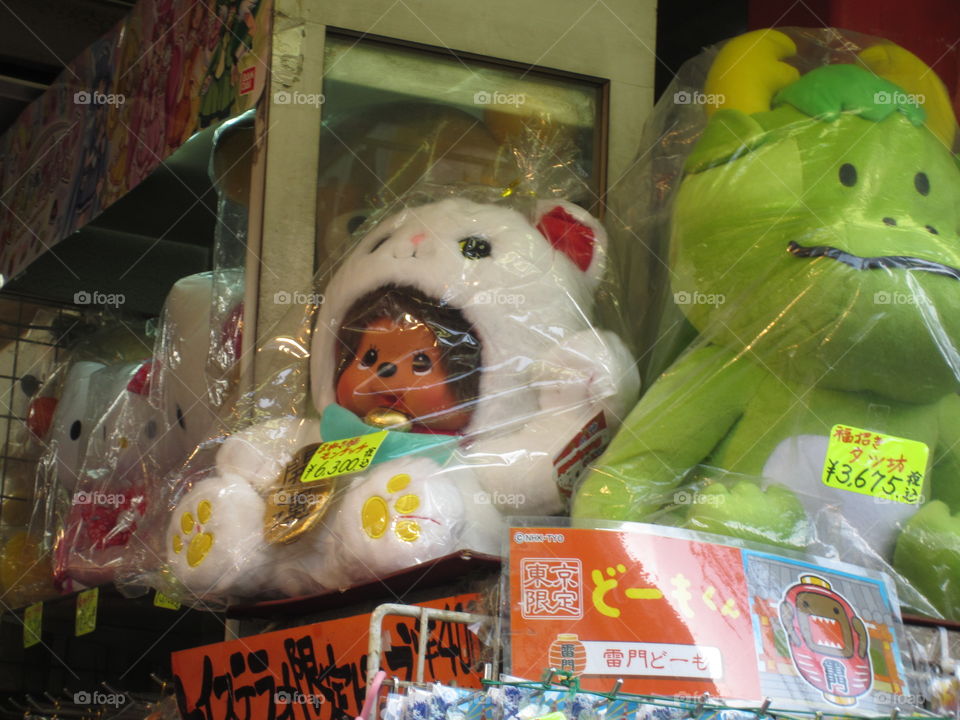 Monchichi dressed as Maneki Neko.  Monkey doll in Lucky Cat outfit. Souvenirs for Sale on Nakamise Street, Asakusa Kannon, Sensoji Buddhist Temple in Tokyo, Japan