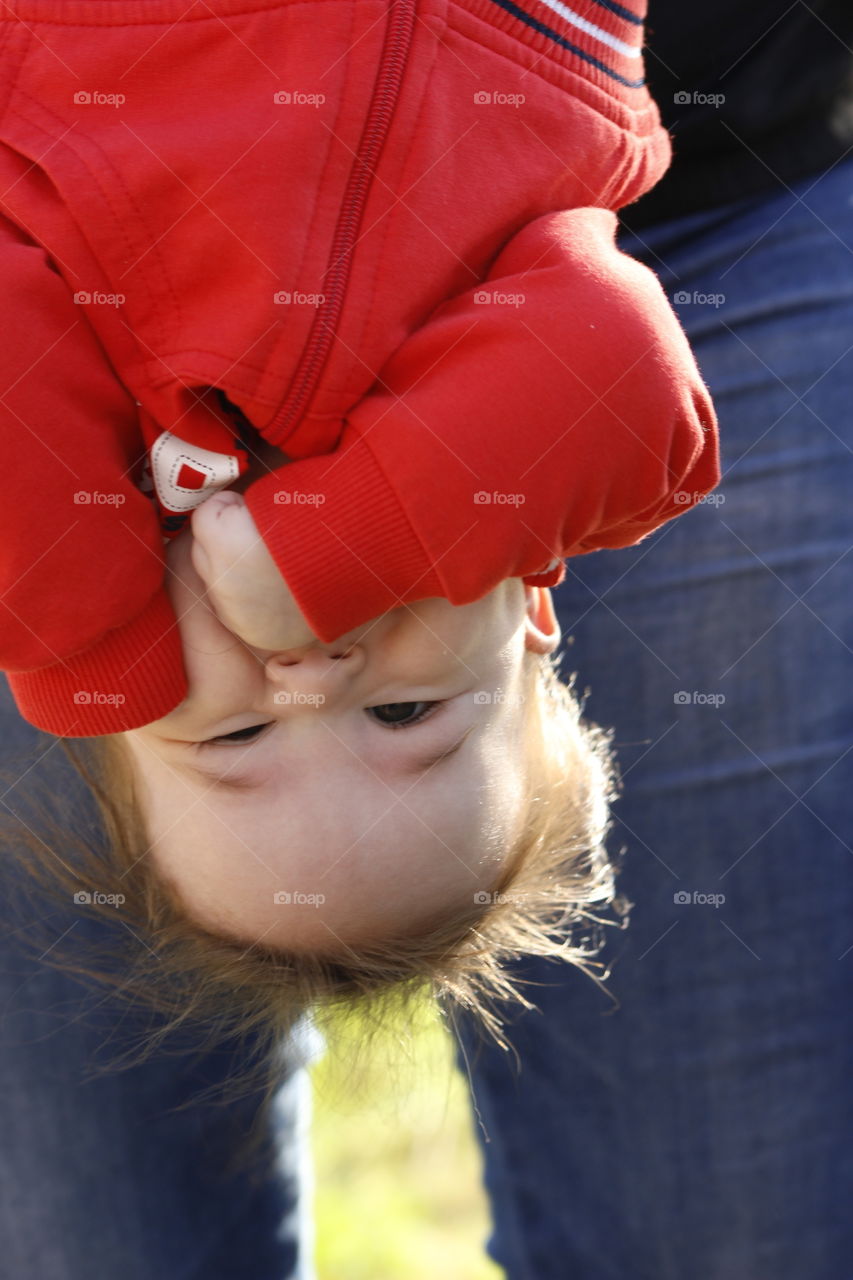 Low section of father holding baby boy upside down