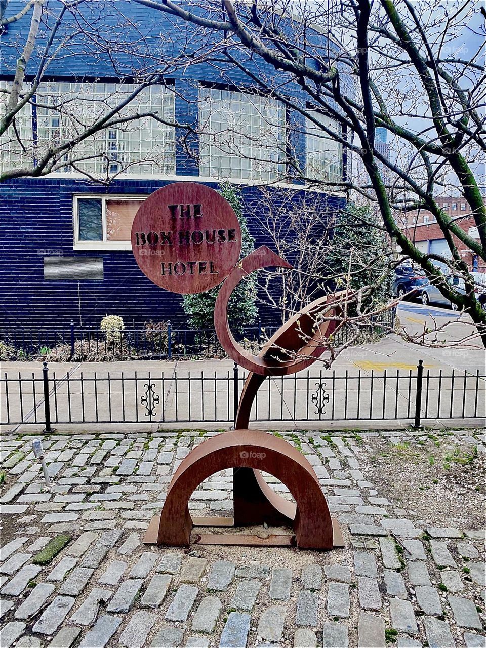 To advertise its presence in “Greenpoint”, Bklyn at “Newtown Creek” by the “Pulaski Bridge” the “BOXHOUSE Hotel” added a futuristic looking art object, a wooden sculpture sign right in front of the building. 2023. Hypnotic Productions
