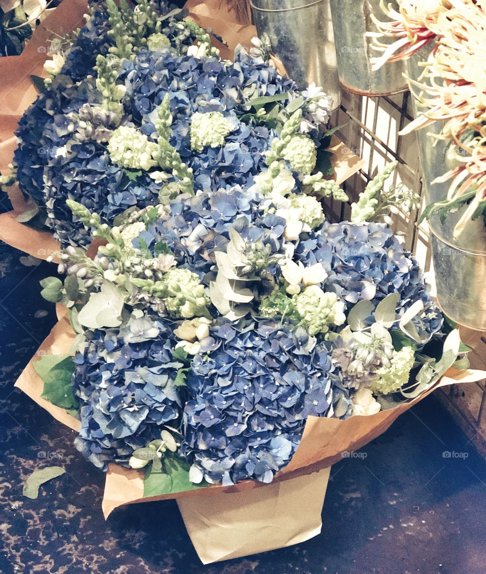Purple and cream hydrangea flower arrangement in brown paper rustic wrapping