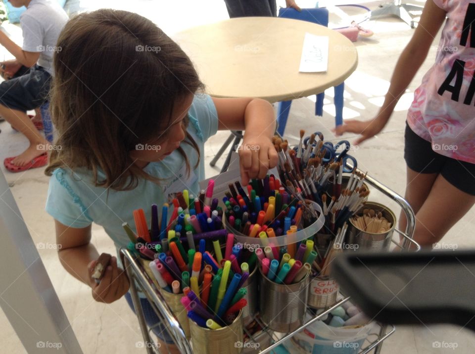 Child choosing colour markers.