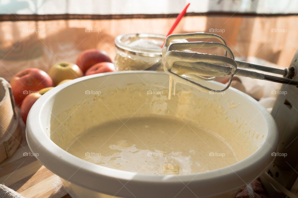 Making an apple pie dough using eggs, flour, sugar and apples.