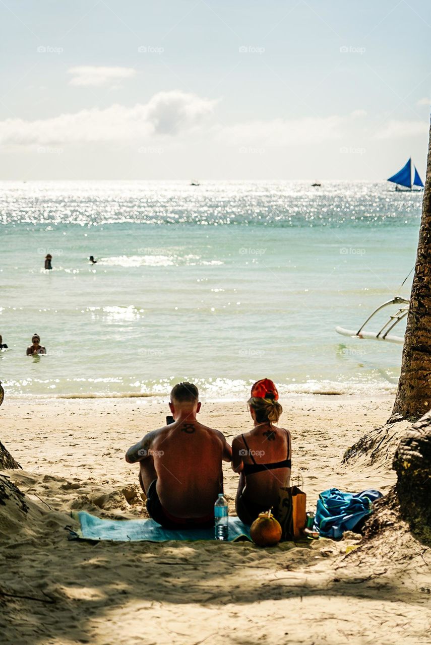 View from behind of a tourist couple during their Summer Vacation. 