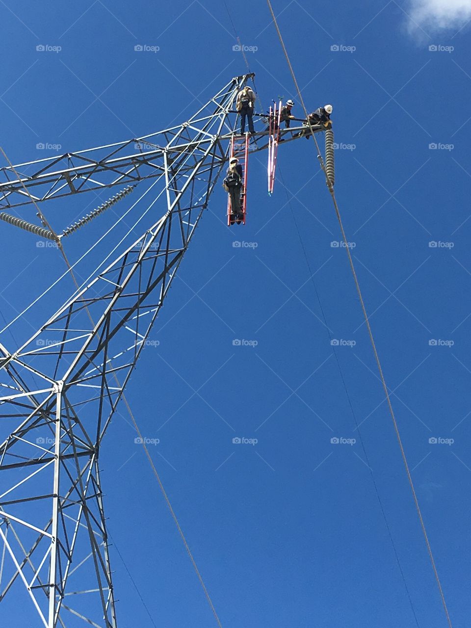 Lineman working from ladder on energized lines. 