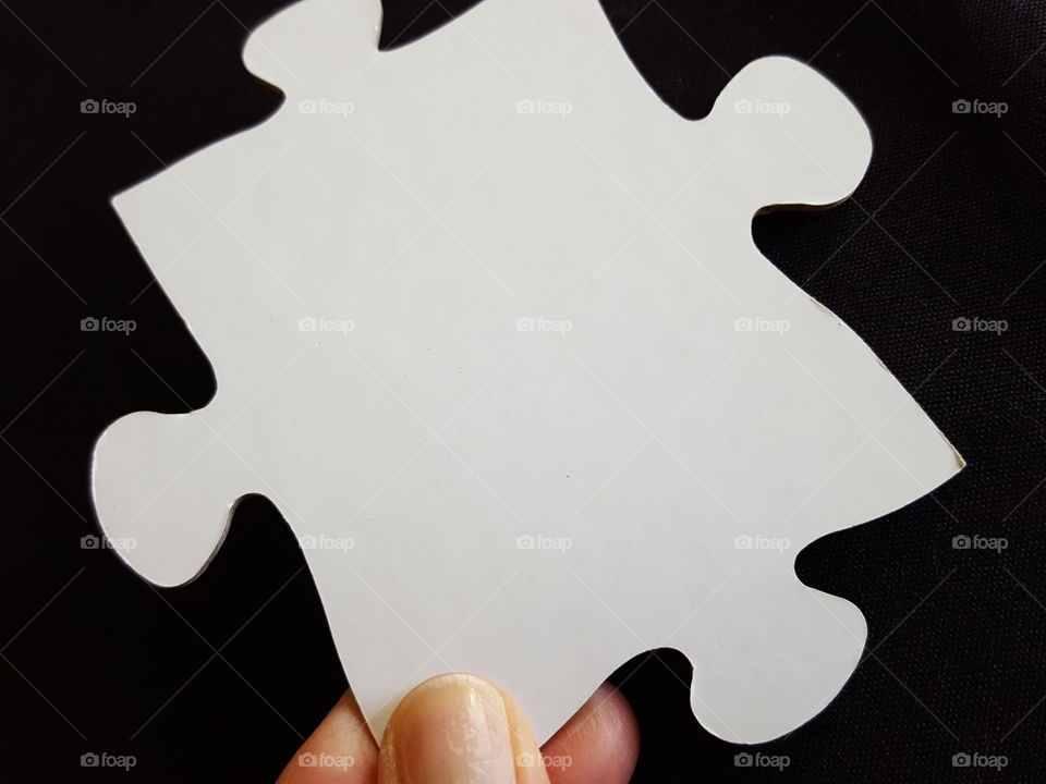 Close-up of human hand holding puzzle piece