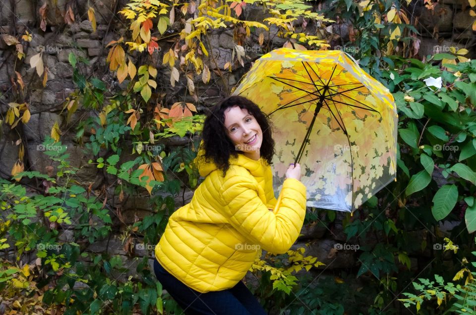 Smiling Woman with Umbrella on Autumn Background